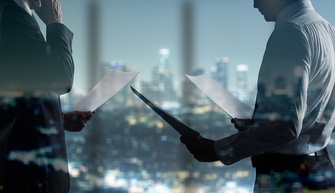 businessman with paper standing in night office